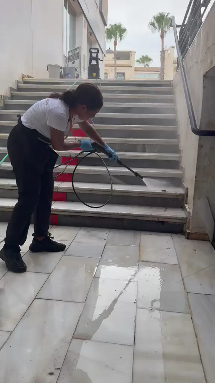 SplendidaClean operative cleaning a communal stairwell in an Orihuela Costa residential community